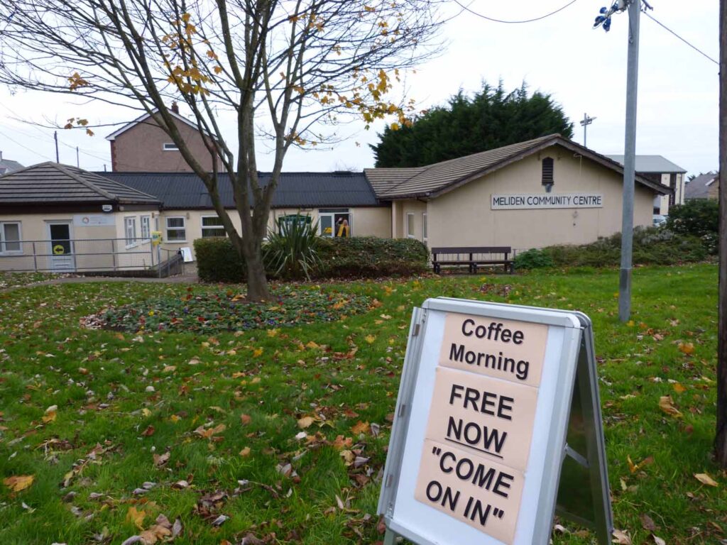 A sign on the grass outside the centre to promote coffee mornings