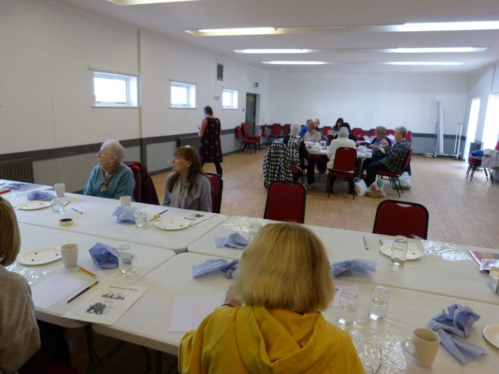 People at craft tables in the village hall